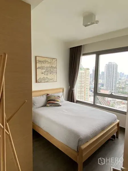 คอนโด ขายในWatthana, Bangkok - ห้องนอนสว่างพร้อมหน้าต่างบานใหญ่ วิวสกายไลน์ เตียงไม้โทนอบอุ่น