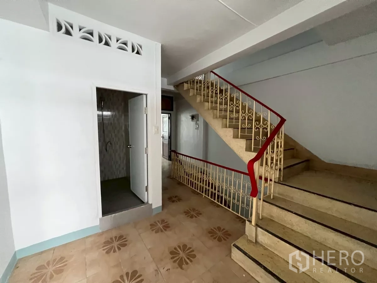 อาคารพาณิชย์ ให้เช่าในKhlong Toei, Bangkok - โถงบันได ราวจับสีแดง และลูกกรงเหล็กตกแต่ง ข้างประตูห้องน้ำ.