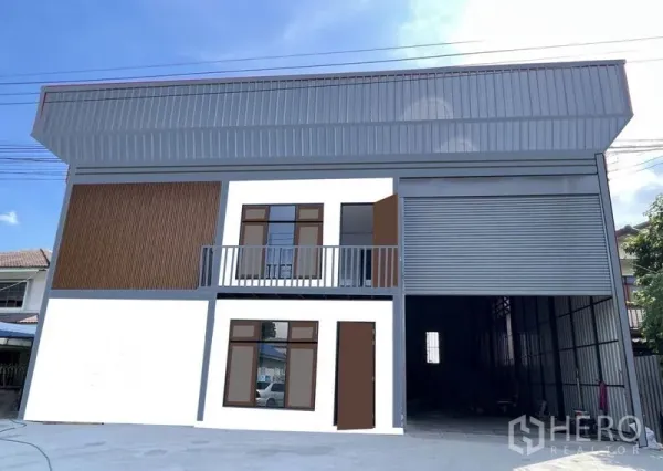 คลังสินค้า ให้เช่าในLam Luk Ka, Pathum Thani - ด้านหน้าตึกมีลานคอนกรีตกว้างและประตูม้วนเต็มความสูง รองรับรถบรรทุกเล็กเข้าออก.