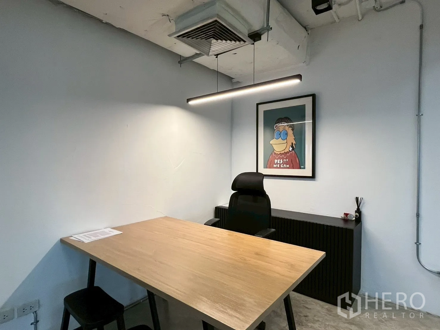 办公室 for rent in Watthana, Bangkok - 独立办公室内木质书桌、办公椅、极简吊灯与装饰画。