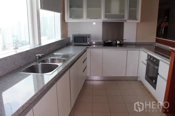 คอนโด ให้เช่าในKhlong Toei, Bangkok - ครัวรูปตัวยูสไตล์โมเดิร์น เคาน์เตอร์หินแกรนิต อ่างล้างจานคู่ หน้าต่างวิวเมือง เตาอบและไมโครเวฟบิลท์อิน