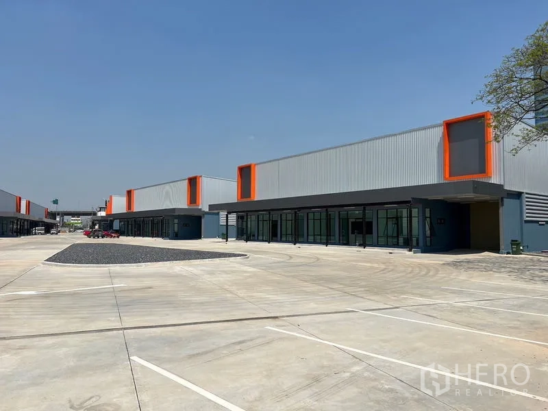 Warehouse for rent in Bang Phli, Samut Prakan - Multiple warehouse units facing a spacious parking court with marked bays