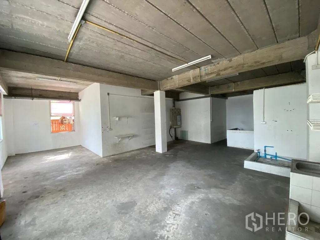 零售空间 出租在Khlong Toei, Bangkok - 开放式水泥房，外露梁、窗户和管线接口。