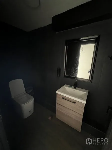 店屋 出租在Watthana, Bangkok - 深色调浴室，带洗手台、镜子与坐便器。