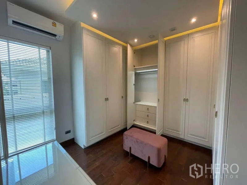 บ้าน ให้เช่าหรือขายในLat Krabang, Bangkok - ห้องแต่งตัวพร้อมตู้บิวท์อินสีขาวโดยรอบ และม้านั่งสีชมพู