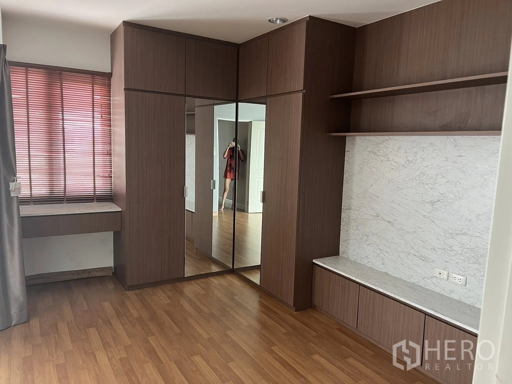 Detached House for rent or sale in Don Mueang, Bangkok - Bedroom with mirrored wardrobe, built-in vanity and shelving.