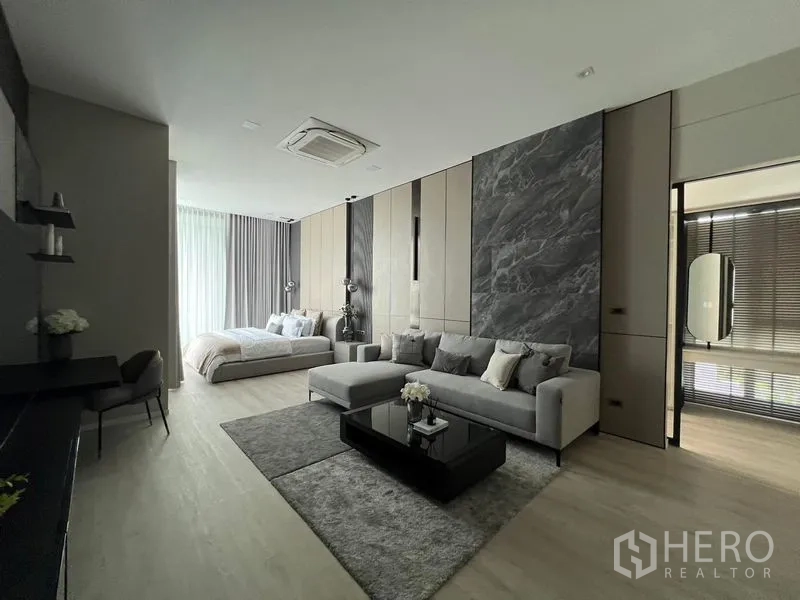 Detached House for rent in Saphan Sung, Bangkok - Grand suite combining lounge and sleeping area with marble feature wall.