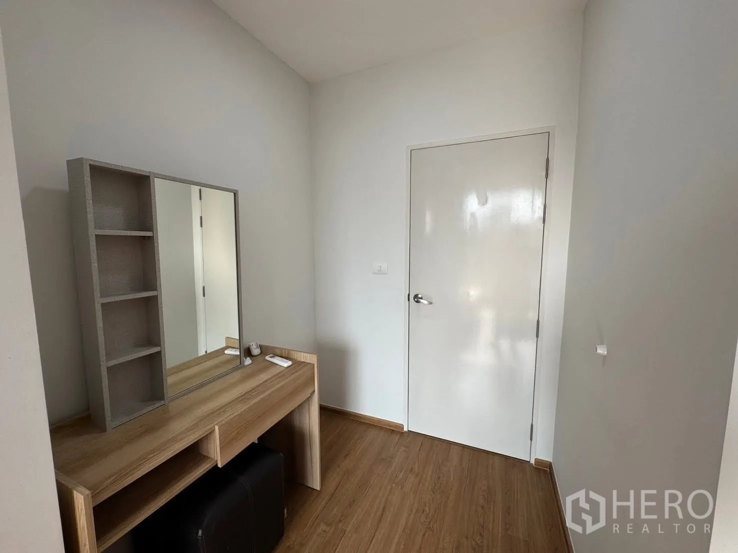 Townhouse for rent in Bang Phli, Samut Prakan - Dressing corner with wooden vanity table, shelves, and a mirror beside a door.