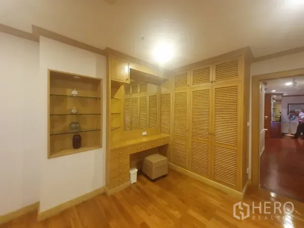 Condominium for rent in Bang Kho Laem, Bangkok - Built-in wardrobes with louvered doors, a dressing vanity with mirror and a display niche on hardwood floors.