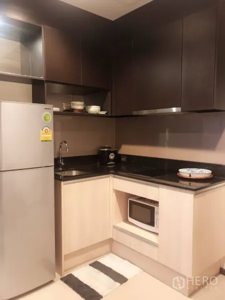 คอนโด ให้เช่าในWatthana, Bangkok - ครัวรูปตัวแอล ตู้สีเข้ม ท็อปหินแกรนิต อ่างล้างจาน เตา ไมโครเวฟ และตู้เย็น