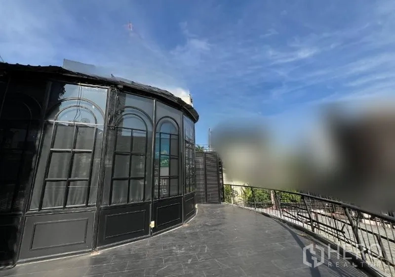 พื้นที่ขายปลีก ให้เช่า - มุมมองด้านข้างของผนังกระจกโค้ง พร้อมทางเดินระเบียงกว้างและราวกันตก