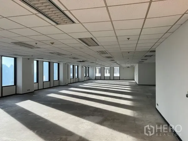 สำนักงาน ให้เช่าในKhlong Toei, Bangkok - พื้นที่สำนักงานเปล่า มีหน้าต่างสูงเรียงต่อกัน เพดานแขวนพร้อมโคมไฟและช่องลมแอร์ รับแสงธรรมชาติเต็มที่