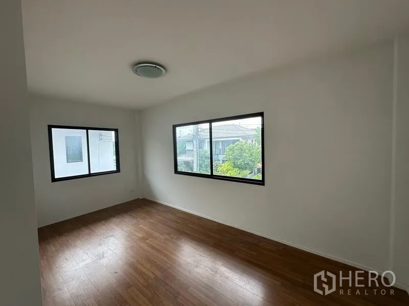 บ้าน ขายในBang Khen, Bangkok - ห้องนอนกว้างพื้นไม้และหน้าต่างบานกว้าง.