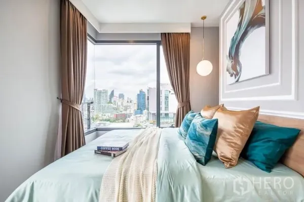 公寓 出租或出售在Watthana, Bangkok - 转角卧室，落地窗城市景观，配吊灯与抽象画。