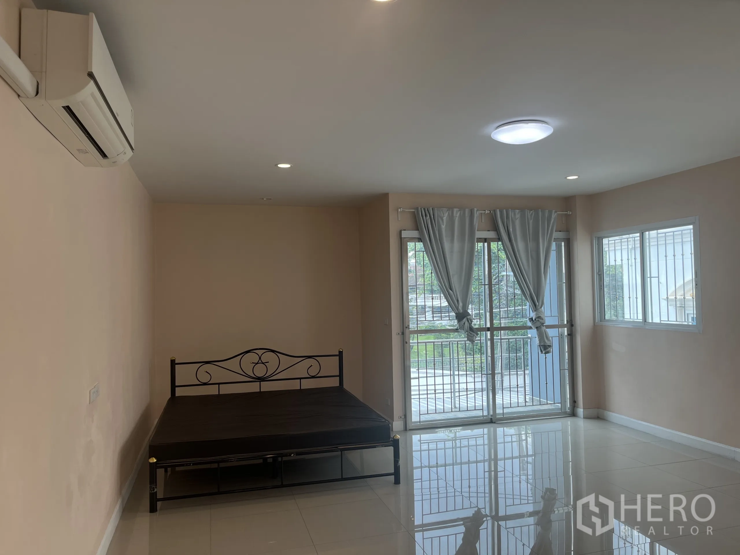 联排别墅 出租在Huai Khwang, Bangkok - 空调卧室，推拉门通阳台，窗帘与瓷砖地面。