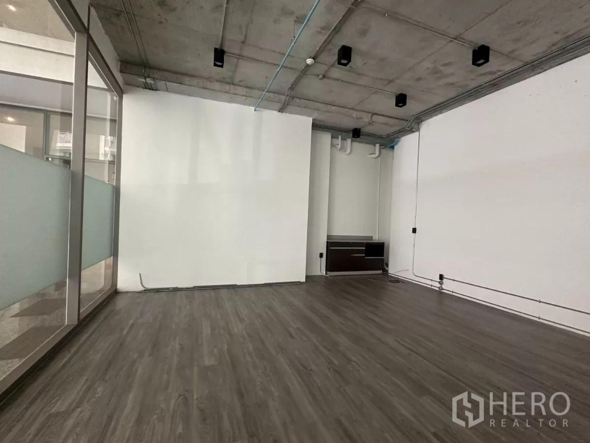 零售空间 出租 - 室内广角图，轨道灯、整面玻璃、木纹地板与可见管线一应俱全。