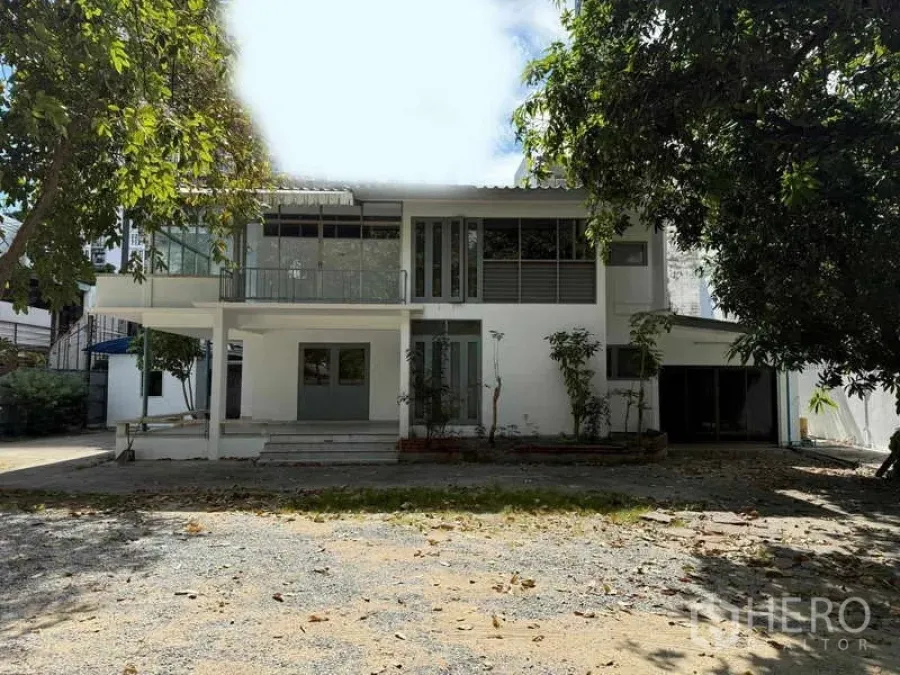 独立式住宅 出租在Watthana, Bangkok - 房屋正立面，前方为宽阔碎石车道与花园。