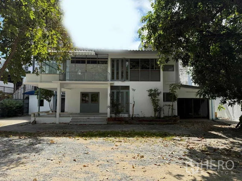 独立式住宅 出租在Watthana, Bangkok - 房屋正立面，前方为宽阔碎石车道与花园。