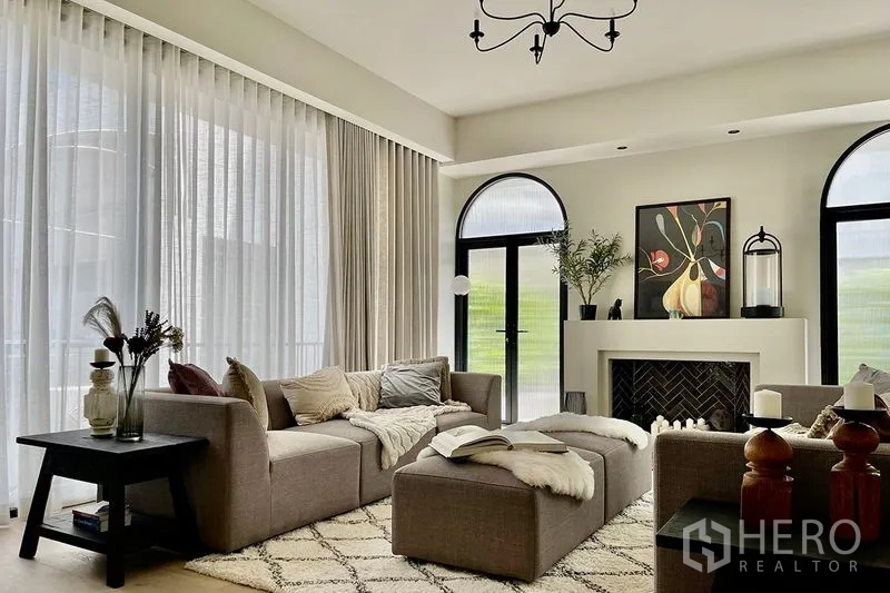 联排别墅 出售在Khlong Toei, Bangkok - 优雅客厅，拱形门、薄纱帘与壁炉为视觉焦点。