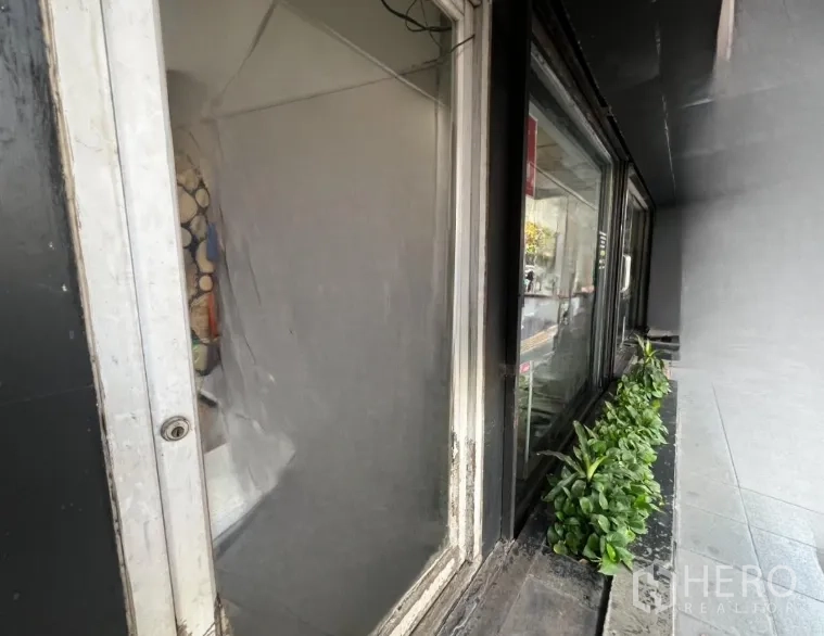 พื้นที่ขายปลีก ให้เช่าในKhlong Toei, Bangkok - ภาพระยะใกล้ของหน้าต่างแสดงสินค้า พร้อมกระบะปลูกต้นไม้แคบๆ