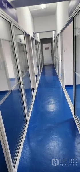 货栈 出租在Bueng Kum, Bangkok - 蓝色环氧地坪走廊，仓库内两侧玻璃隔间。