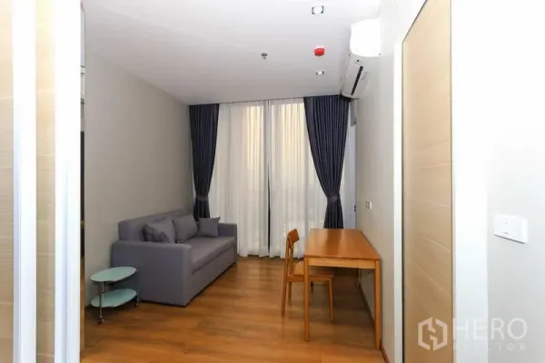 คอนโด ให้เช่าในKhlong Toei, Bangkok - พื้นที่นั่งเล่นหรือห้องทำงานรอง พร้อมโซฟา โต๊ะเขียนหนังสือ และผ้าม่านทึบสูง