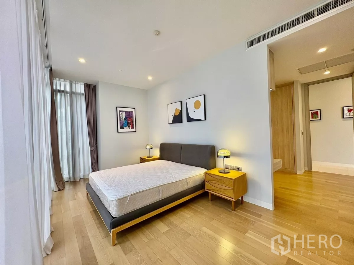 คอนโด ให้เช่าในWatthana, Bangkok - ห้องนอนมาสเตอร์มุมห้อง พื้นไม้ โต๊ะหัวเตียง ใกล้ทางเข้าห้องน้ำในตัว