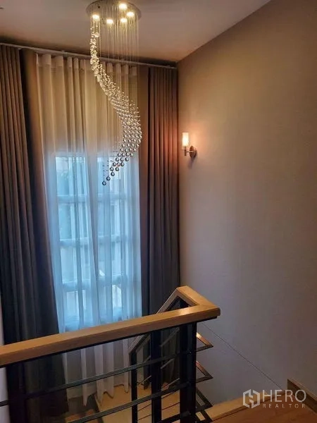 Detached House for sale in Bueng Kum, Bangkok - Stairwell with tall window and spiral crystal chandelier.