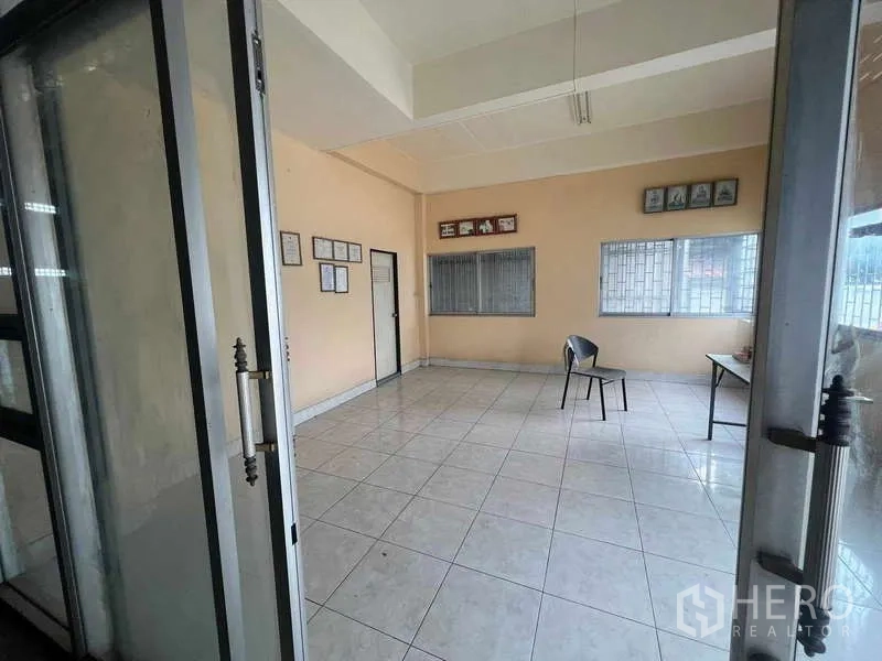 Warehouse for rent in Lam Luk Ka, Pathum Thani - Tiled office space behind glass doors with windows and simple furnishings.