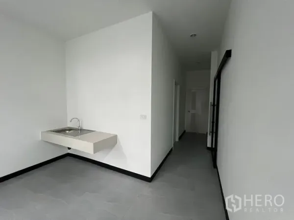 Warehouse for rent in Chon Buri - Clean pantry area with wall-mounted sink and corridor leading to restrooms.