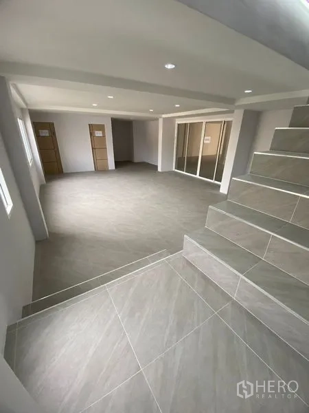 สำนักงานที่บ้าน ให้เช่าหรือขายในSuan Luang, Bangkok - มุมมองจากบันไดสู่พื้นที่สำนักงานกว้าง พร้อมผนังกระจกและแสงธรรมชาติ