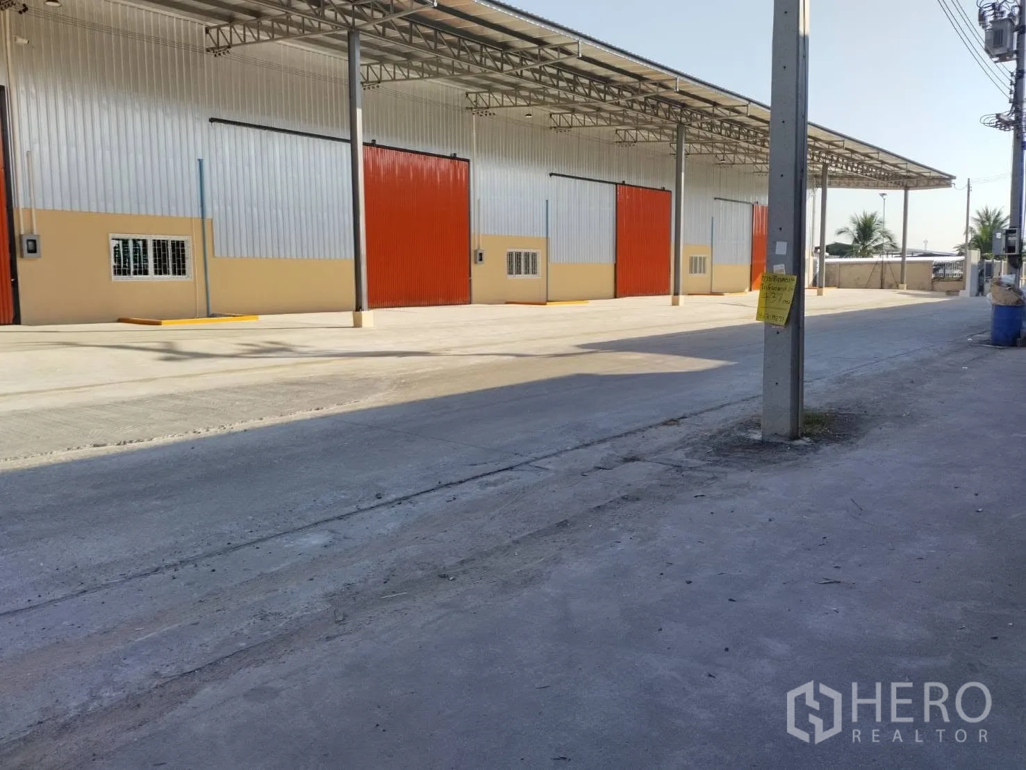 โกดัง for rent in Khlong Luang, Pathum Thani - ด้านหน้าโกดังพร้อมหลังคาคลุม พื้นที่โหลดกว้าง และลานคอนกรีตริมถนน