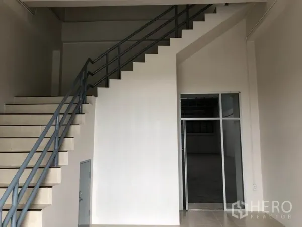 工厂 出租在Pak Kret, Nonthaburi - 入口前厅，楼梯与通往仓库的玻璃门。