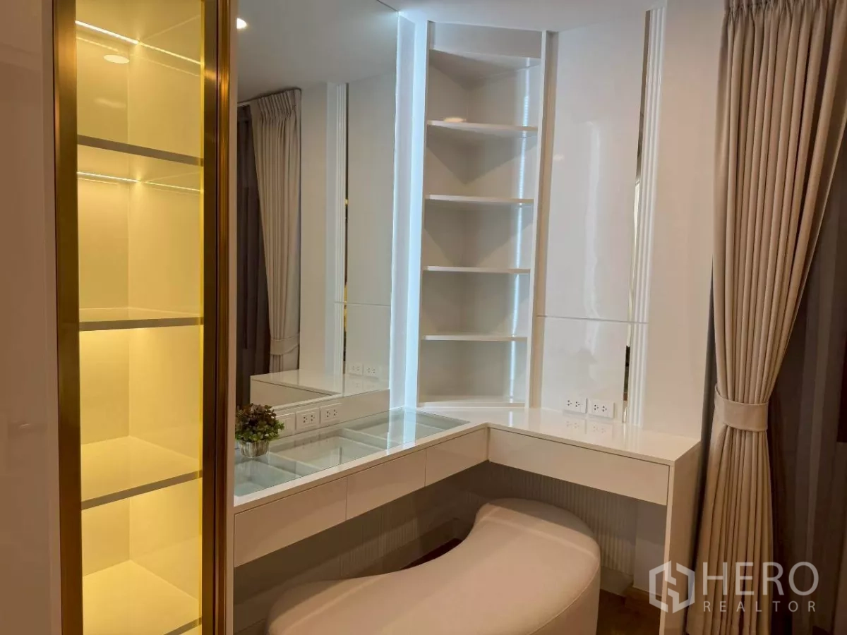 独立式住宅 出租在Bang Phli, Samut Prakan - 带照明的展示柜与玻璃搁板，紧邻梳妆台。