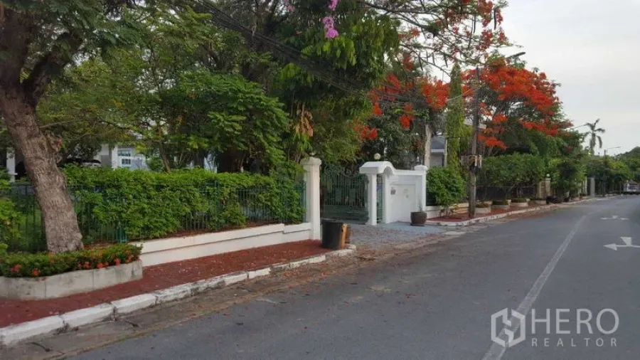 Detached House for rent in Bang Phli, Samut Prakan - Front boundary wall and green fence of the house on a quiet street.