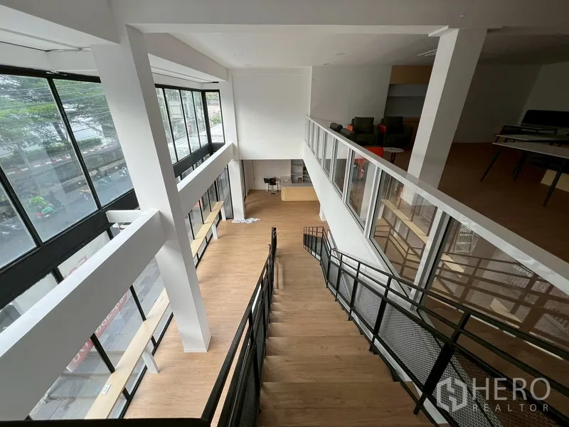 零售空间 出租在Watthana, Bangkok - 连接首层与夹层的楼梯，位于明亮挑高空间