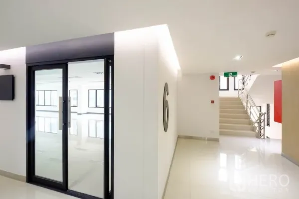 สำนักงาน ให้เช่าในChatuchak, Bangkok - โถงทางเดินสว่างพร้อมประตูกระจกหมายเลข 6 และบันไดข้างกัน