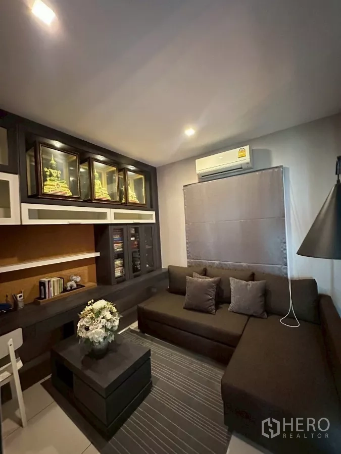 Detached House for sale in Bang Lamung, Chon Buri - Built-in study or prayer room with shelving and corner sofa.