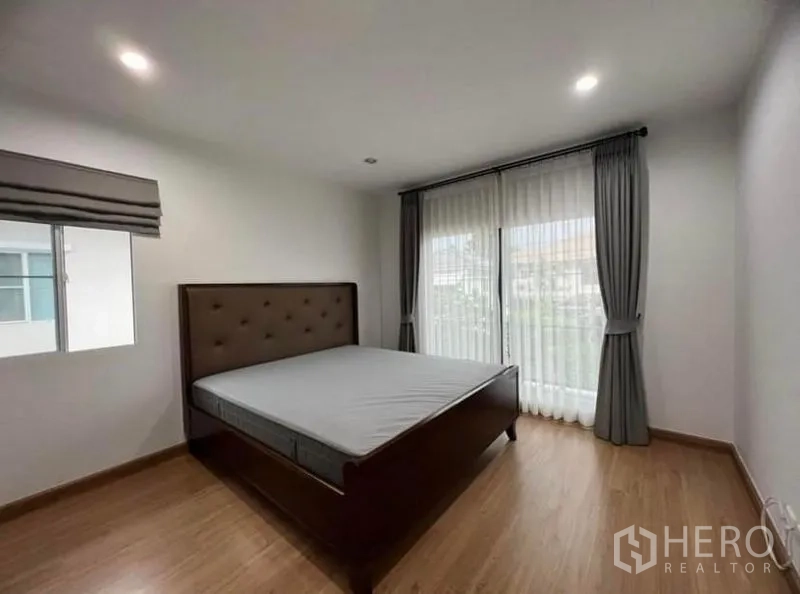 独立式住宅 出租在Suan Luang, Bangkok - 主卧另一视角，大窗与灰色窗帘