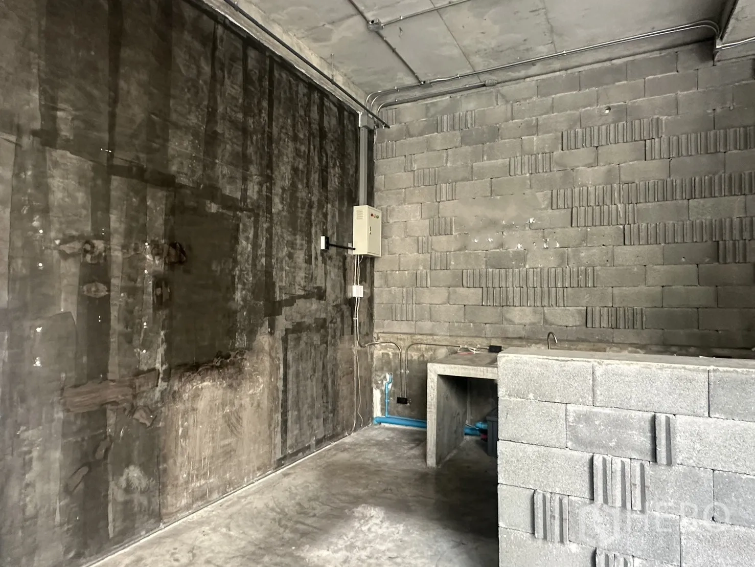 พื้นที่ขายปลีก ให้เช่าในPhra Khanong, Bangkok - ด้านหลังห้อง โชว์ผิวปูนดิบ กล่องไฟ และเคาน์เตอร์ทำงาน