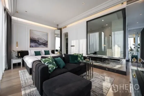 公寓 出租在Bang Rak, Bangkok - 开放式卧室与起居区，玻璃隔断浴室与现代装饰。