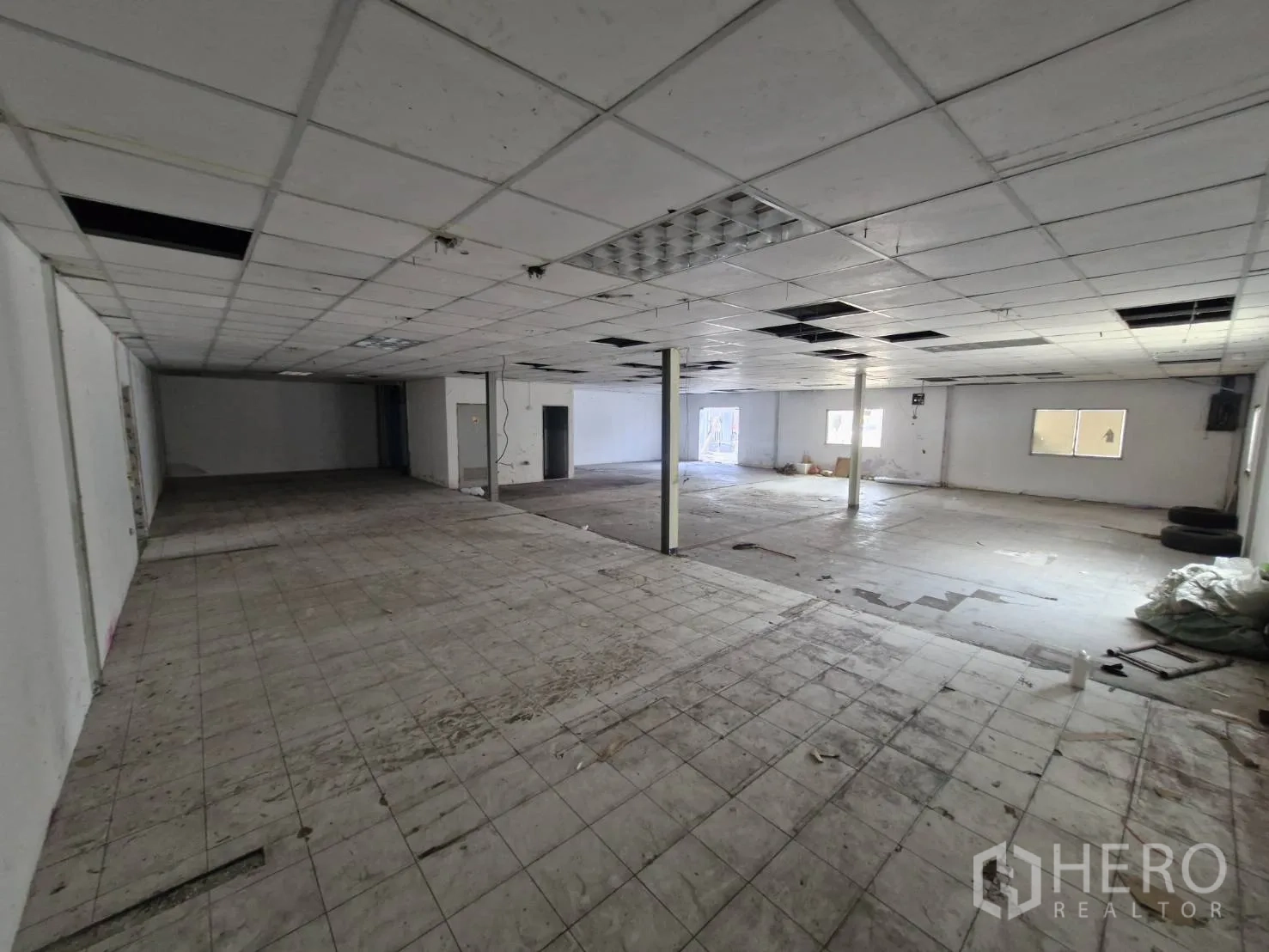 Warehouse for rent in Suan Luang, Bangkok - Expansive upper floor with drop ceiling tiles and windows.