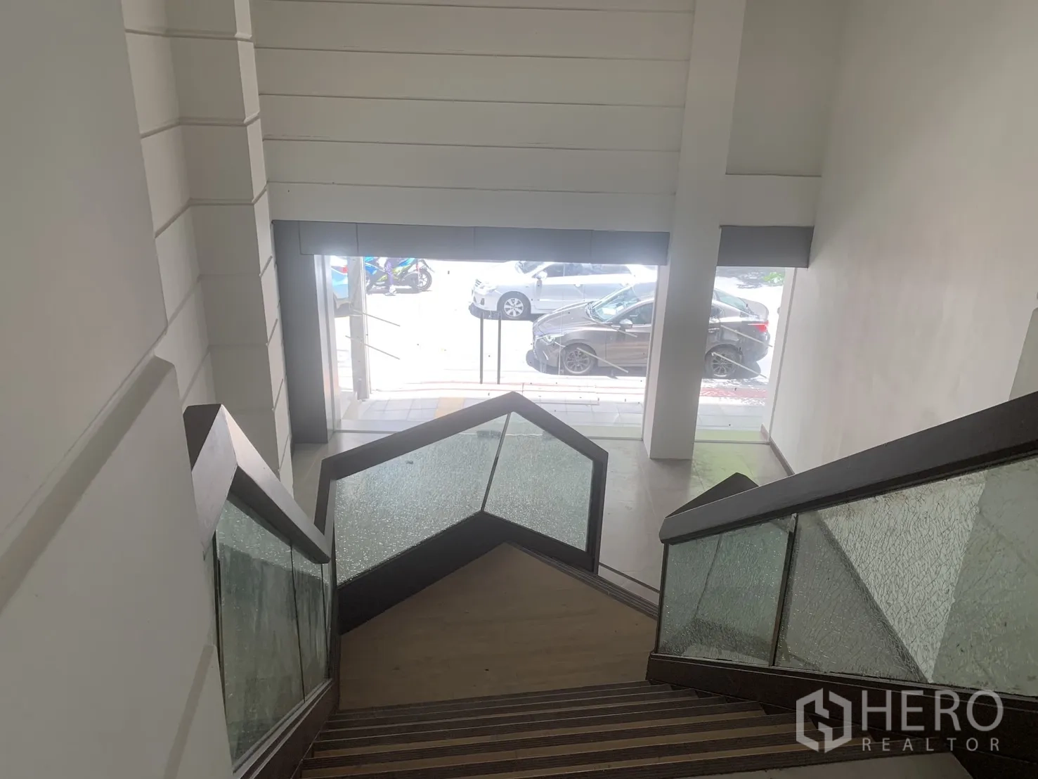零售空间 for rent in Bang Rak, Bangkok - 从楼梯望向临街玻璃门面与人行道景致。