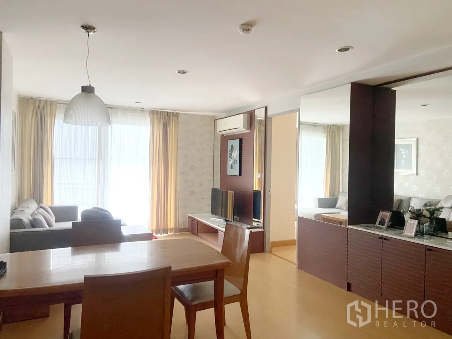 คอนโด ให้เช่าในWatthana, Bangkok - พื้นที่นั่งเล่นเปิดโล่งพื้นไม้ ผนังทีวี และหน้าต่างบานใหญ่รับแสงธรรมชาติ