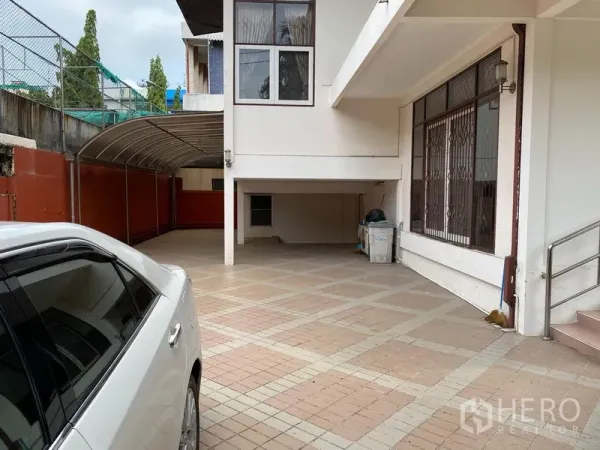 บ้าน ให้เช่าในKhlong Toei, Bangkok - ลานจอดรถปูพื้นกระเบื้องพร้อมกันสาดและพื้นที่ลานชั้นล่างกว้างของบ้านเดี่ยวสองชั้น