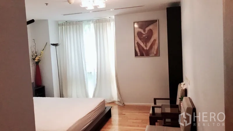 公寓 出租在Bang Rak, Bangkok - 次卧平台床，柔和窗帘与窗边座椅。