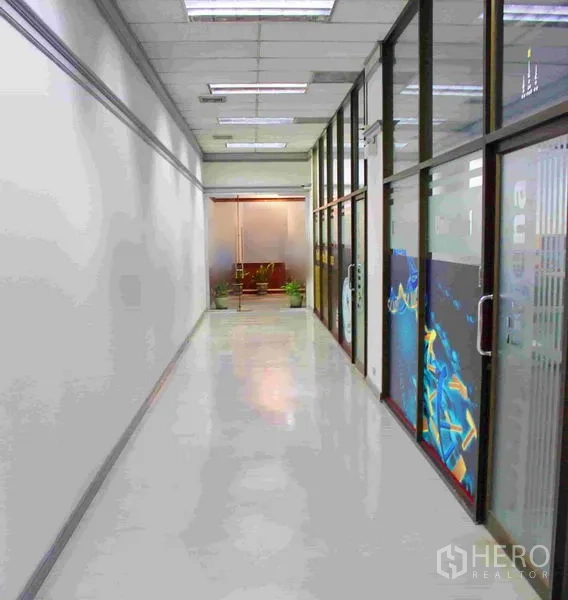 Office Space for rent in Lak Si, Bangkok - Bright corridor with polished floors and glass-partitioned offices leading to a lobby area.