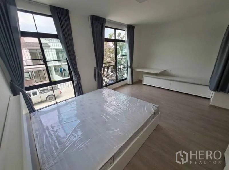 ทาวน์เฮาส์ ให้เช่าในBang Phli, Samut Prakan - ห้องนอนชั้นบน หน้าต่างมุมกว้าง พร้อมระเบียงเล็ก มองเห็นบ้านรอบข้าง