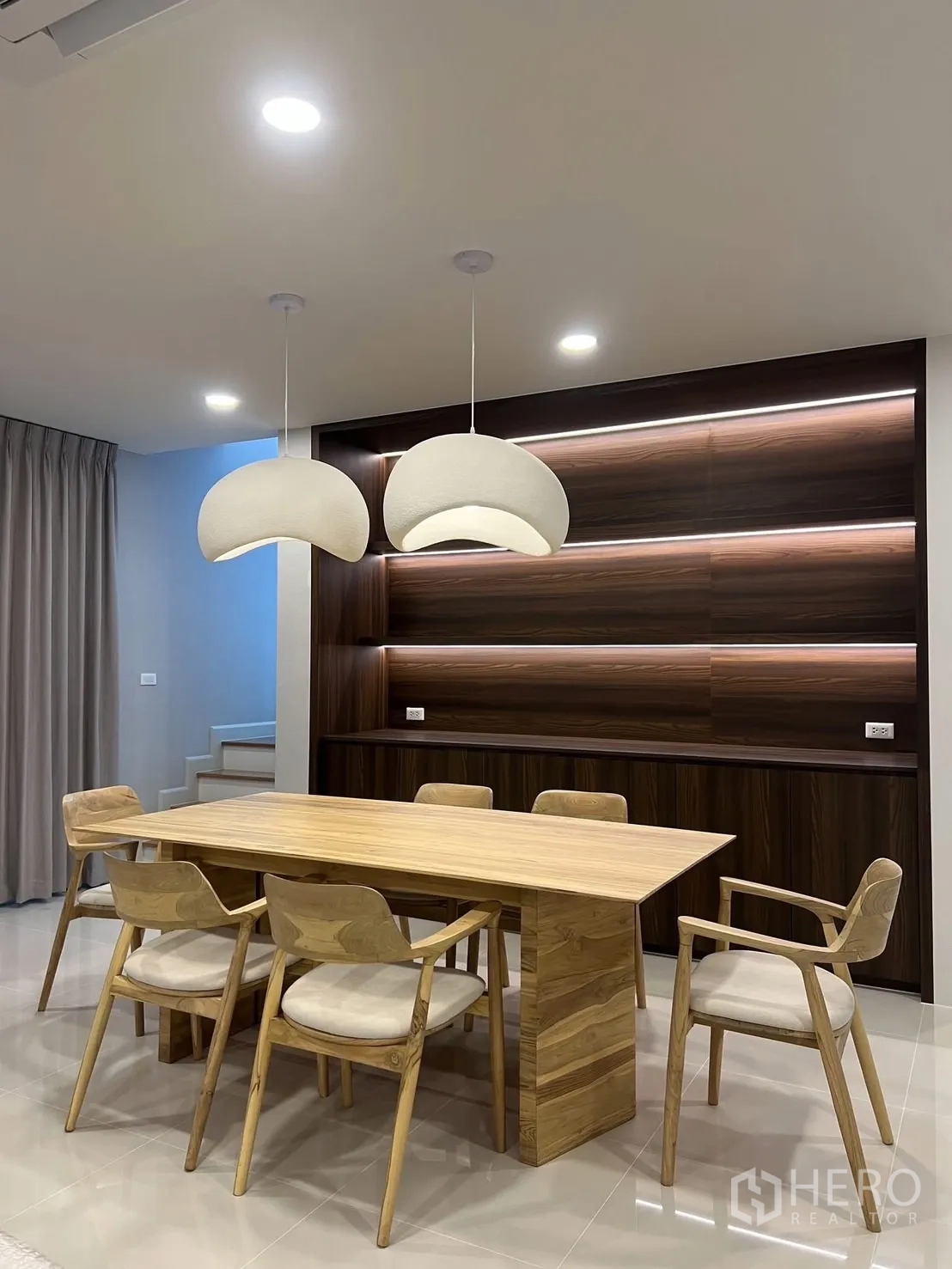 Detached House for rent in Bang Phli, Samut Prakan - Minimalist dining room with solid wood table, six chairs and sculptural pendant lamps.