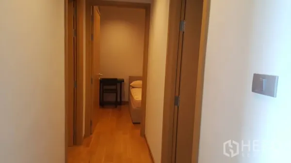 คอนโด ให้เช่าในWatthana, Bangkok - โถงทางเดินสว่าง พื้นไม้ ประตูไม้ เปิดสู่พื้นที่ห้องนอนในคอนโดสมัยใหม่